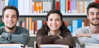 a group of people sitting at a table in front of books.