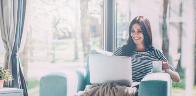 a woman sitting on a couch with a laptop.