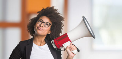 a woman holding a red and white megaphone.