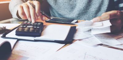 a person sitting at a desk with a calculator.